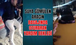 Suya gömülen aracının bagajında oturarak yardım bekledi